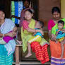 Flood-hit women smile as they get a safe corner to feed their babies